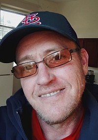 Chad Freeman owner of GuestGuard Pest Solutions in St. Louis Mo. Wearing blue and red with a St. Louis Cardinals hat